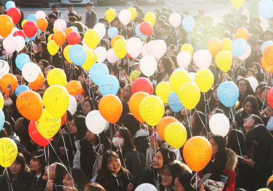 대학수학능력시험을 이틀 앞둔 14일 오후 경기도 수원시 영통구 효원고등학교에서 3학년 학생들이 수능 소망을 담은 풍선을 들고 있다.